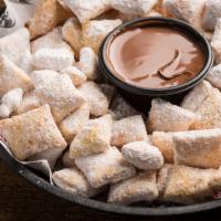 Zeppole · Bite-sized pieces of crispy dough tossed in powdered sugar and paired with rich Nutella haze...