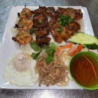 40. Com Dac Biet · Special rice combo. Grilled honey lemongrass and pork chop, shrimp pork, skewer and sunny sh...