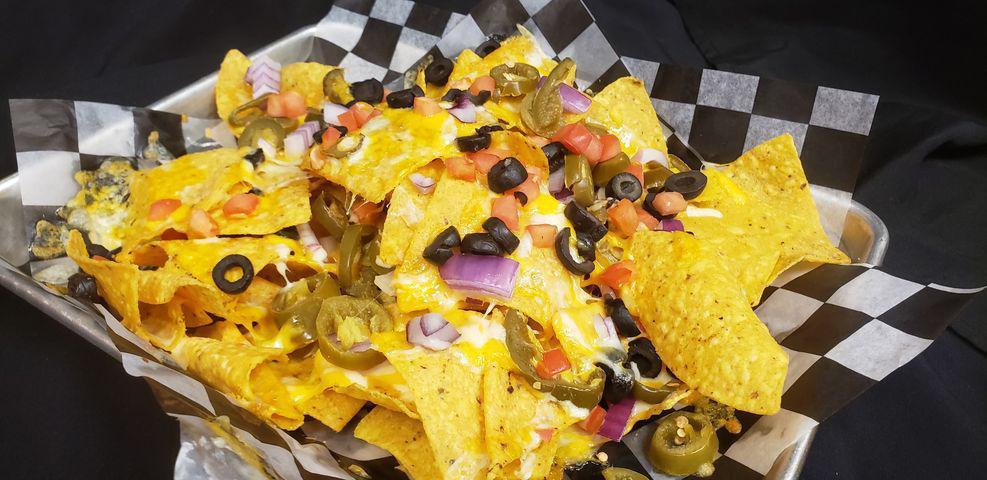 Nachos  · Corn tortilla chips, black olives, tomatoes, jalapenos, red onions, melted cheddar jack. Served with salsa & sour cream. Add extras for an additional charge.