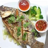 E6. Fried Whole Fish · Fried whole fish served with steamed vegetables and chilly sauce.