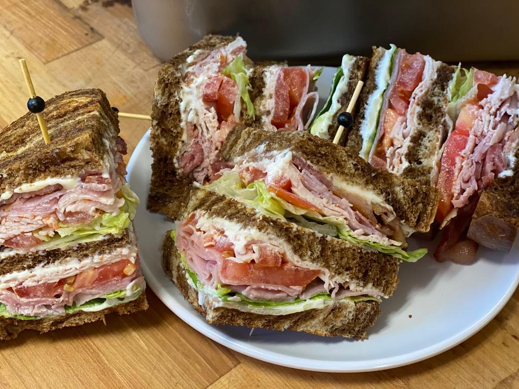 Club House · Turkey, ham, and bacon triple-decker sandwich with fresh lettuce, tomato, and mayo on your choice of artisan bread. Served with fries or slaw.