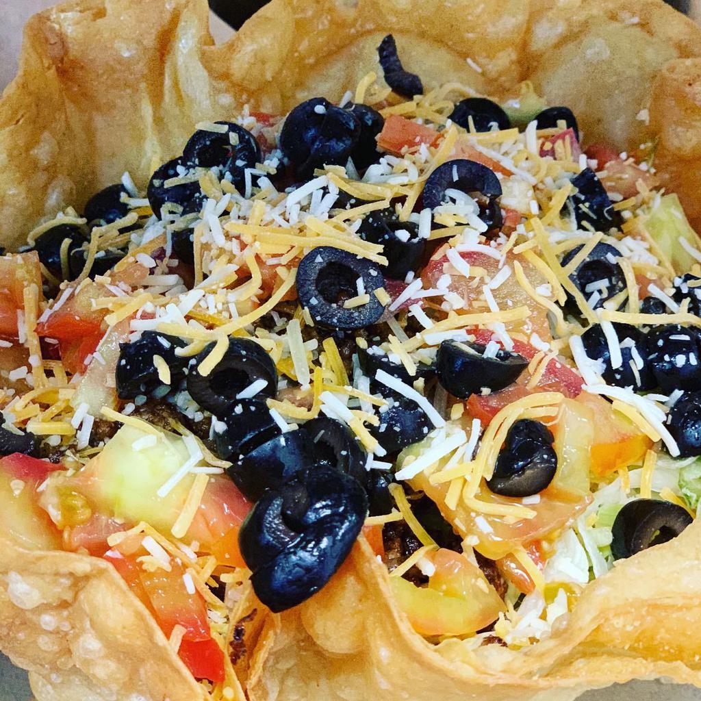 Taco Salad · Seasoned ground beef, lettuce, olives, tomato refried beans, Cheddar Jack cheese with sour cream, and pico de gallo in a tortilla bowl.