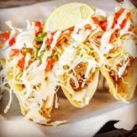 Fish Tacos · Hand-dipped beer-battered fish with shredded cabbage, cilantro lime sauce, and a side of pic...