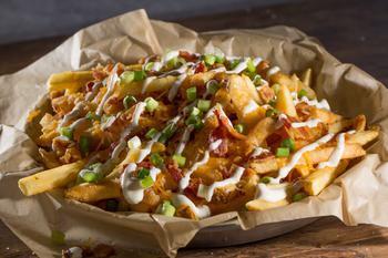 Bacon Cheese Fries · Our fries topped with a generous portion of Cheddar Jack cheese, a layer of chopped bacon, Ranch and fresh scallions.
