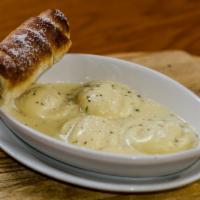 Lobster Ravioli · 5 lobster-filled medallions in a brandy cream sauce. Served with bread.