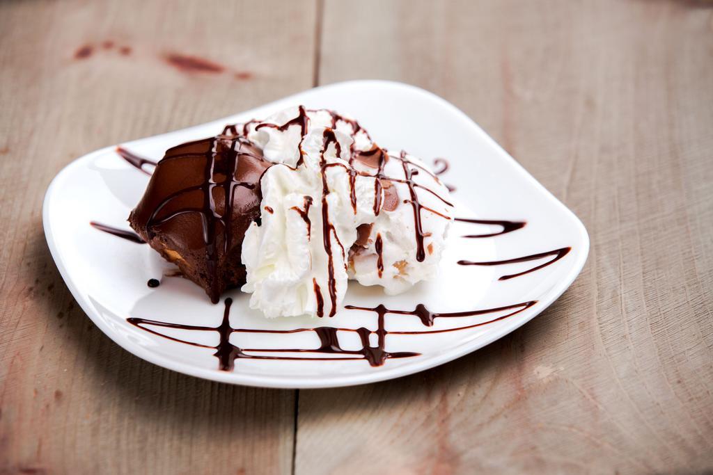Dark Profiteroles · Cream puffs filled with chocolate and coated in vanilla cream.