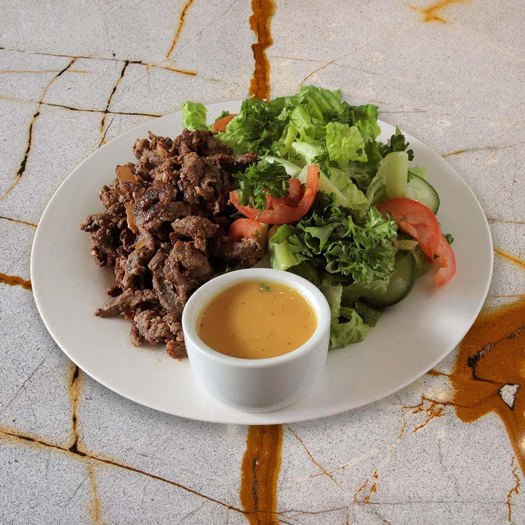 Lamb Shawarma Salad (GF) · Grilled lamb shawarma over crispy romaine lettuce, tomatoes, cucumbers, and parsley, with our tangy lemon garlic dressing.