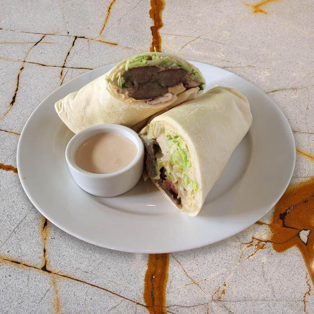 Kafta Sandwich · Original hummus, charbroiled seasoned beef mixed with parsley and onion, served on our house pita bread with lettuce, tomato, onion and our garlic tahini sauce.
