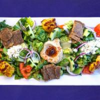 Mediterranean Salad · A hearty mixed green salad, fresh tomatoes, red onion,cucumber, hummus, Kalamata olives topp...