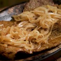 Bistec Palomilla Encebollado · Grilled thin sirloin steak with onions.