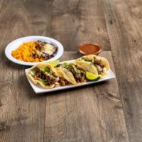 Tacos de Carne Asada · Corn tortillas with grilled steak topped with onions and tomatillo sauce on side.