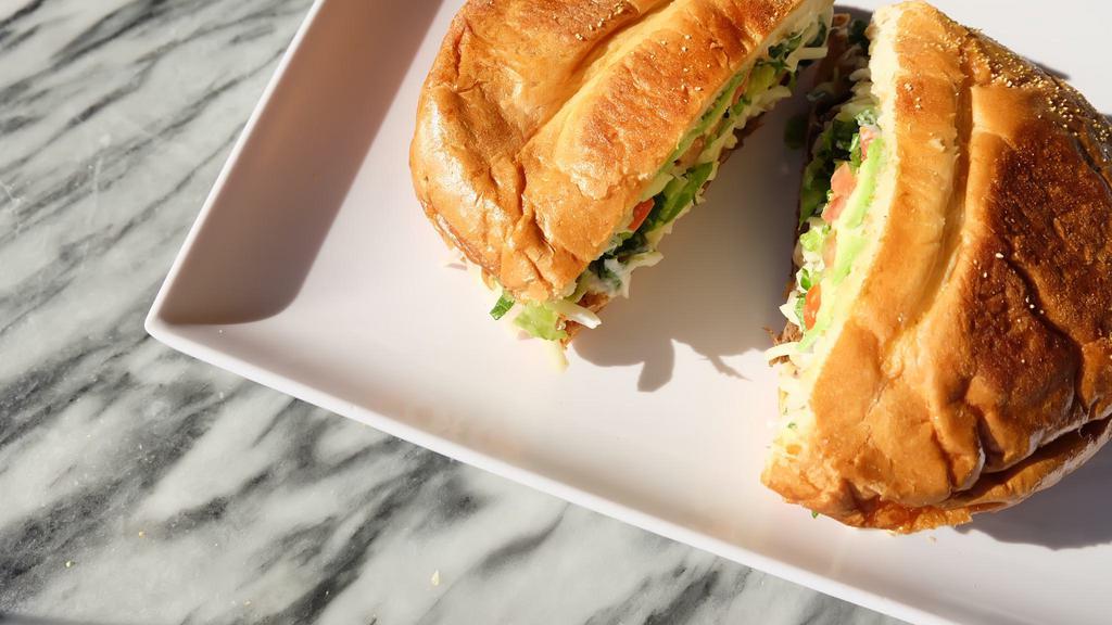 Chorizo Torta · Served with Mexican blend cheese, lettuce, tomato, beans, avocado, and sour cream.