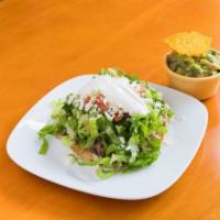 Asada · Steak tostada with beans, lettuce, tomato, sour cream and queso fresco (Mexican shredded che...
