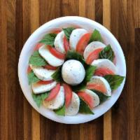 Caprese Salad · Fresh mozzarella slices layered with tomato and fresh basil leaves, drizzled with extra virg...