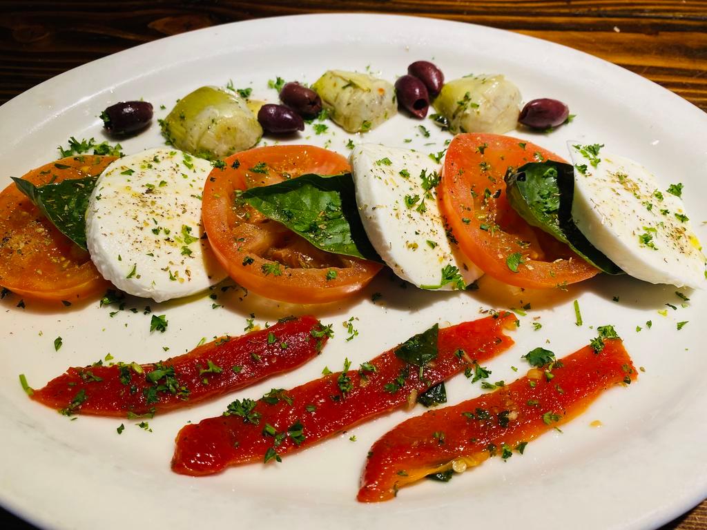 Caprese · Fresh Buffalo mozzarella over fresh sliced tomatoes, artichoke hearts, roasted red peppers, and Kalamata olives with basil and extra virgin olive oil.