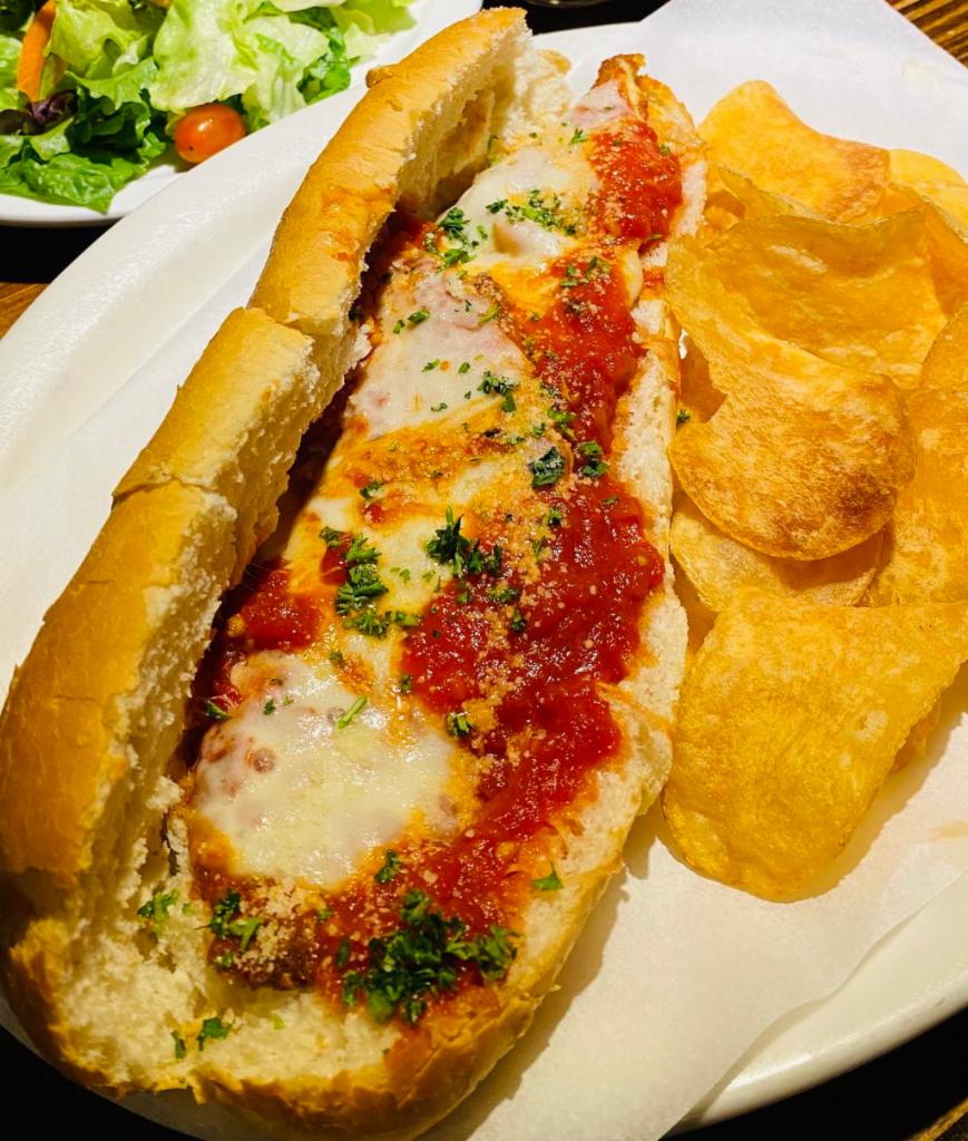 Eggplant Sandwich · Lightly breaded fried eggplant, topped with marinara sauce and melted mozzarella, served on a fresh Italian roll with our house-made chips. 