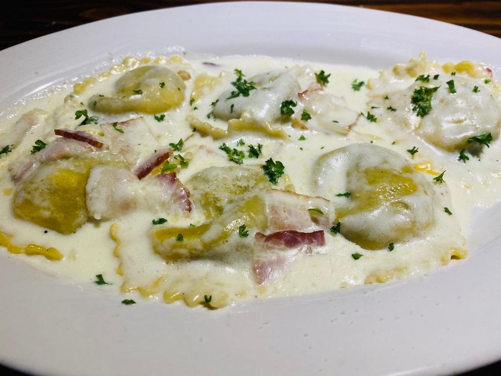 Ravioli Carbonara · Meat ravioli filled in a cream sauce with sauteed bacon. Your Choice of Soup or Salad & Garlic Bread.