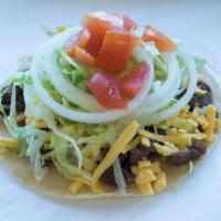 Beef Taco · Served with cheese, onions, lettuce, tomato and hot sauce.