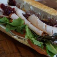 Turkey · Hand sliced all-natural turkey, provolone, cranberry sauce, mixed greens, roma tomatoes, may...