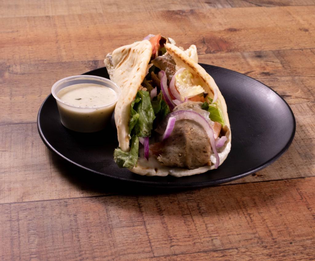 The Classic Gyro Wrap · Rotisserie style roasted lamb and beef wrapped in pita bread, topped with lettuce, tomatoes, red onions and tzatziki sauce.