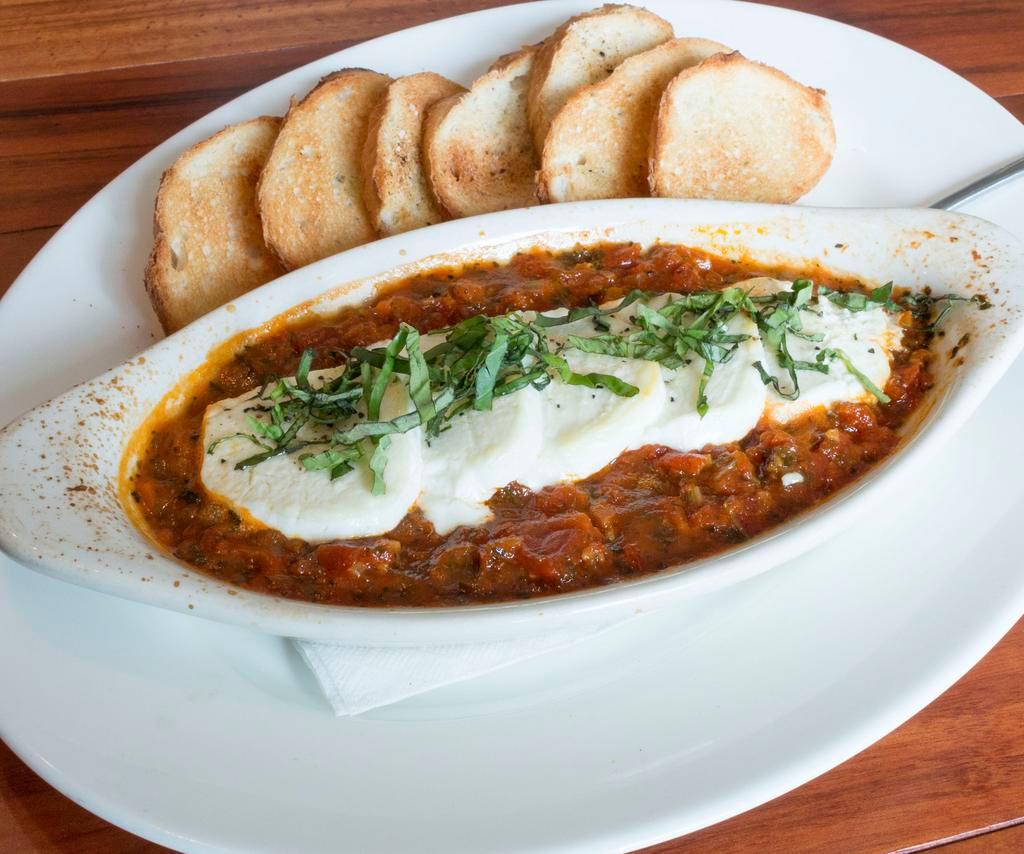 Baked Goat Cheese · Sliced goat cheese baked in our spicy arrabbiata sauce with fresh basil. Served with toasted crostini.