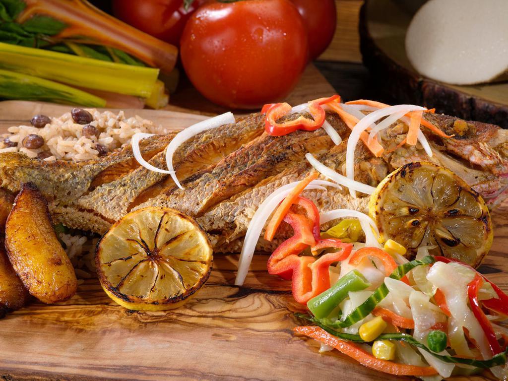Escovitch snapper Fish Meal · Served across most Jamaican beach-front restaurants, this perfectly fried red snapper comes marinated in a zesty sauce of vinegar, spices, onions, carrots, and peppers. A taste of home.