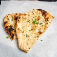 Garlic Naan · Leavened white bread baked in the tandoor with garlic and fresh cilantro. 