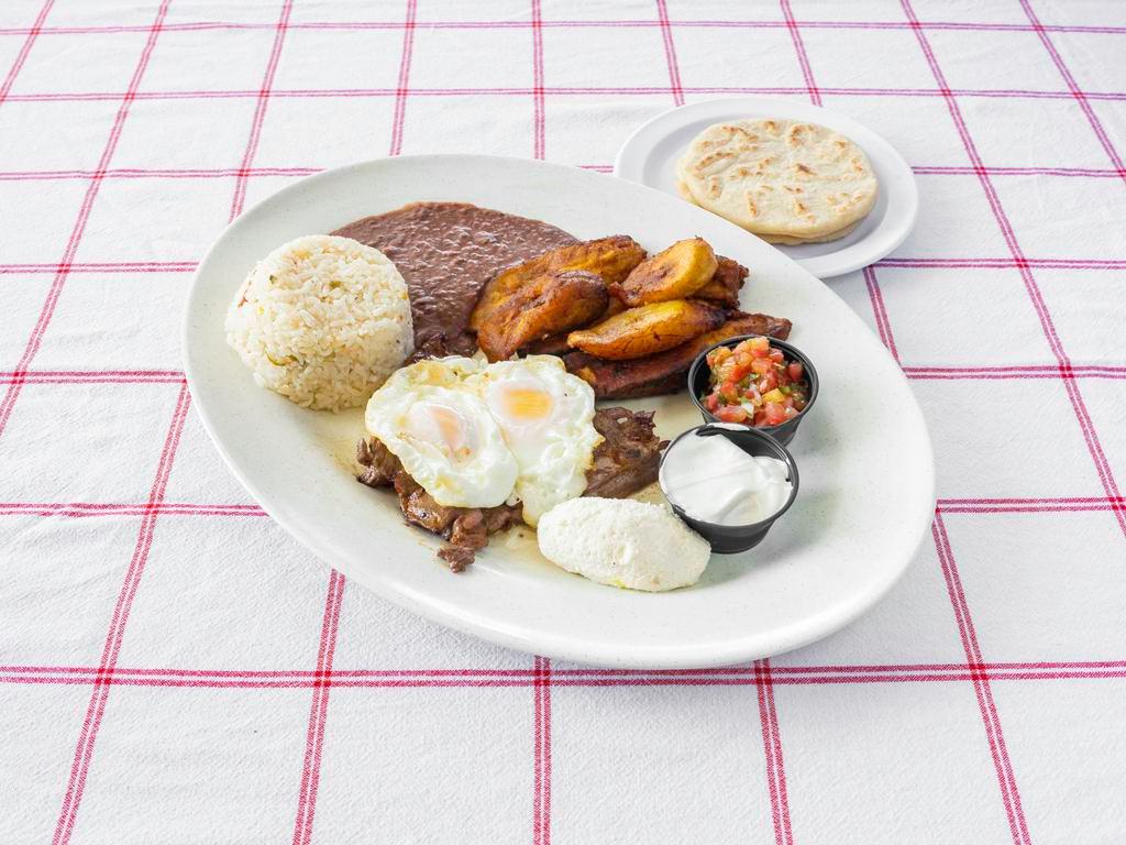 Desayuno Hondureno · Grilled steak carne asada, 2 eggs over easy, fried plantains, rice, beans, sour cream, cheese, and salsa.