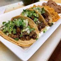 Taco Dinner Steak · 3 authentic tacos with onion and cilantro only. Includes a side of rice and beans.