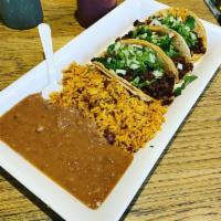 Taco Dinner · 3 authentic tacos with onion and cilantro only. Includes a side of rice and beans.