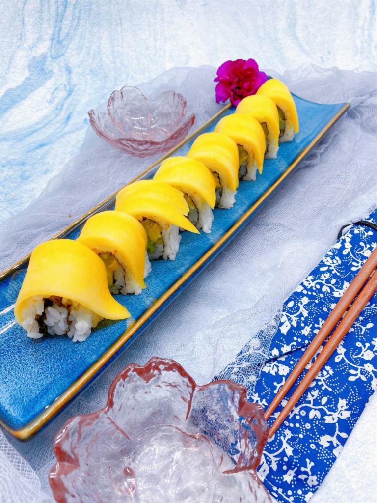 S9. Mango Roll · Crab, avocado, cucumber with mango on top with special mango sauce.