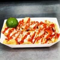 Papas Encueradas · Kettle cooked potato chips covered with pickled pork grinds, sour cream, hot sauce and lime.
