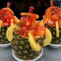 Pinaventura con Fruta · Half pineapple with a mix coctel fruit inside with skwinkles and a tamaroca (mexican candies...
