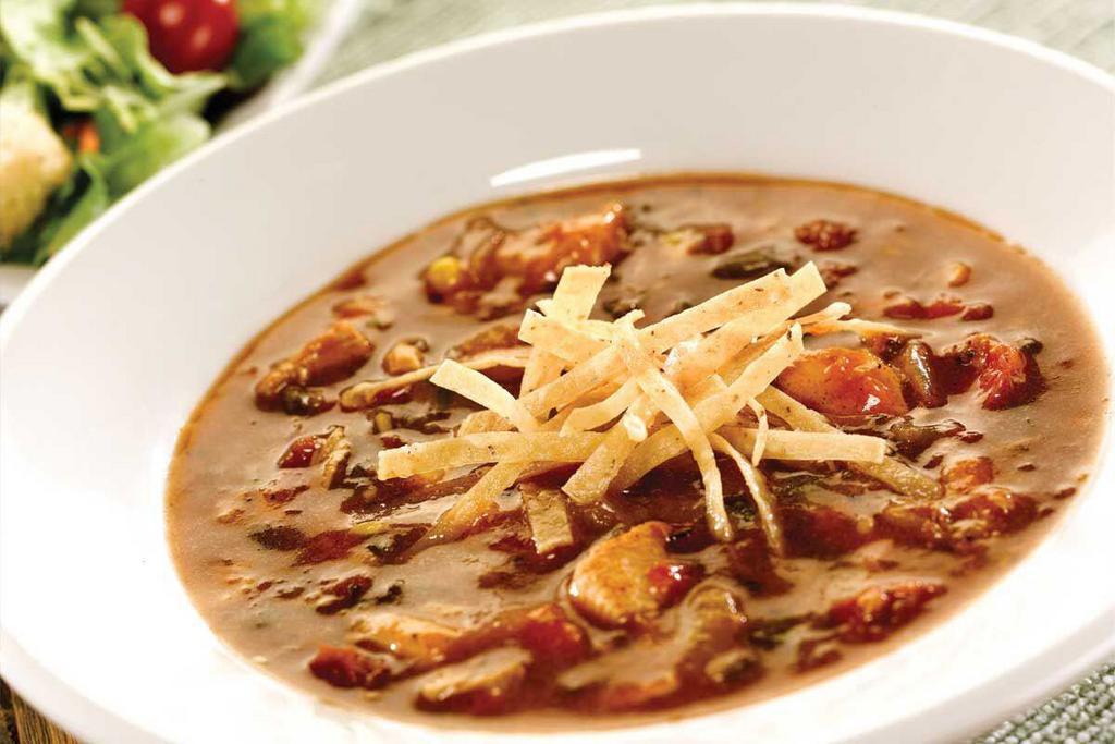 Chicken Tortilla Soup · Zesty, spicy soup with chicken, green Chile peppers, tomatoes, ground tortillas and cumin. 
