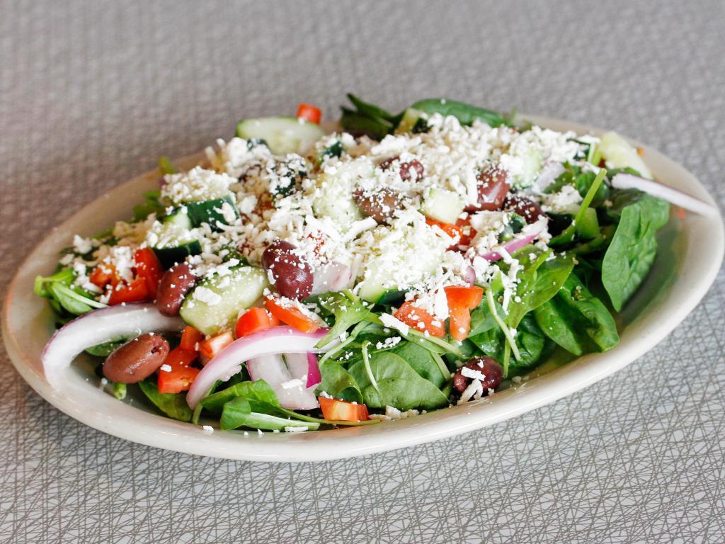 Greek Salad · Cucumbers, fresh tomatoes, oregano, red onion, kalamata olives and feta cheese on a bed of spinach leaves, served with feta vinaigrette.