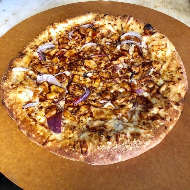 BBQ Chicken Pizza · Texas style marinated chicken, red onions, tomatoes and feta cheese atop BBQ sauce base.