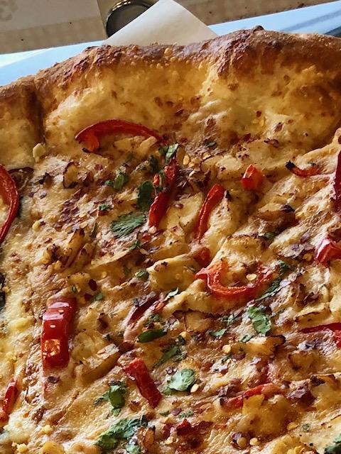 Spicy Thai Pizza · Garlic chicken, roasted red peppers, crushed red peppers and cilantro on a spicy peanut sauce base. Spicy.