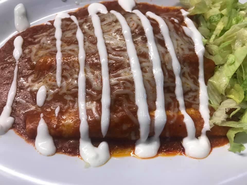 Chicken enchiladas (2) · Two chicken enchiladas topped with enchilada sauce, cheese, lettuce and sour cream.