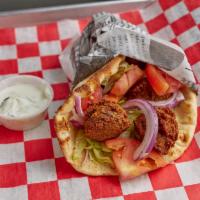 Falafel Pita · Fried seasoned ground chick peas lettuce, tomato, and red onions with tzatziki on the side.