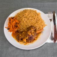 Uzbeki Qabuli Pulao · Braised lamb shank served over a bed of rice and garnished with sweet raisins and carrots. T...