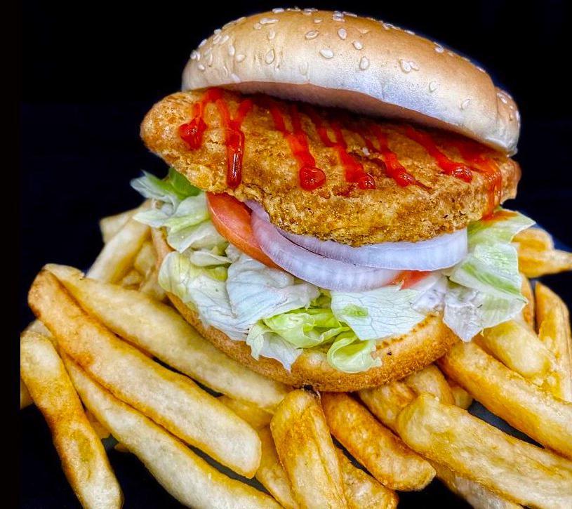 Crispy Chicken Sandwich with Fries · Crispy Chicken Sandwich with, lettuce, tomato, sliced onions, ketchup, and mayonnaise on a seeded bun with french fries.