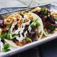 TWO Smoked Brisket Tacos · The Eastside's favorite taco - smoked brisket topped with fresh greens, crispy fried onions,...