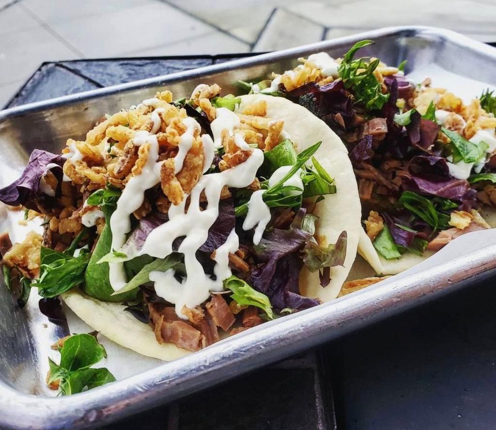 TWO Smoked Brisket Tacos · The Eastside's favorite taco - smoked brisket topped with fresh greens, crispy fried onions, and horseradish crema. 