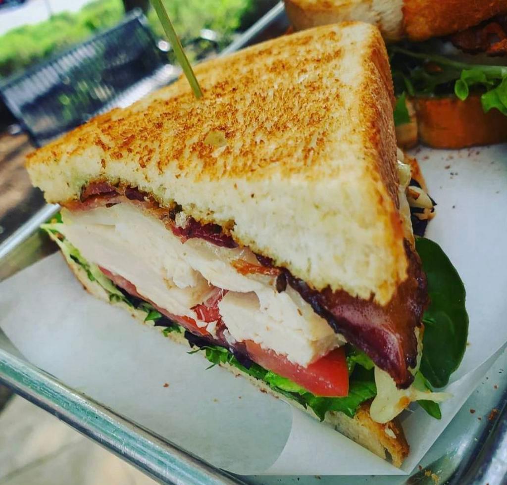 Eastside Turkey Club · Sliced turkey breast topped with smoked bacon, provolone, tomatoes, greens, and pesto aioli, on toasted sourdough bread. 