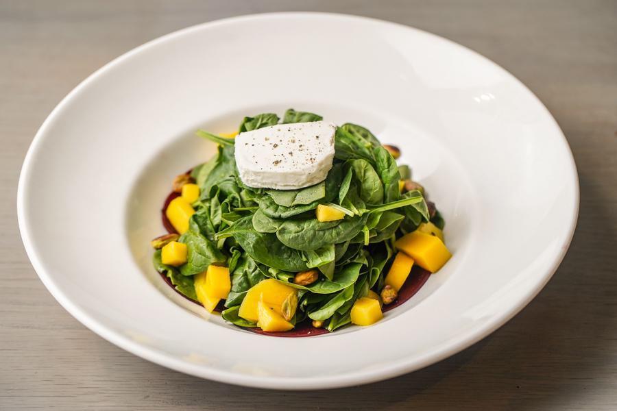 Spinaci Insalata · Baby Spinach, Red Beets, Goat Cheese, Fresh Mango and Pistachio Nuts.