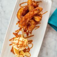 Churros · Fried dough tossed in cinnamon sugar with melted chocolate sauce and a scoop of vanilla ice ...