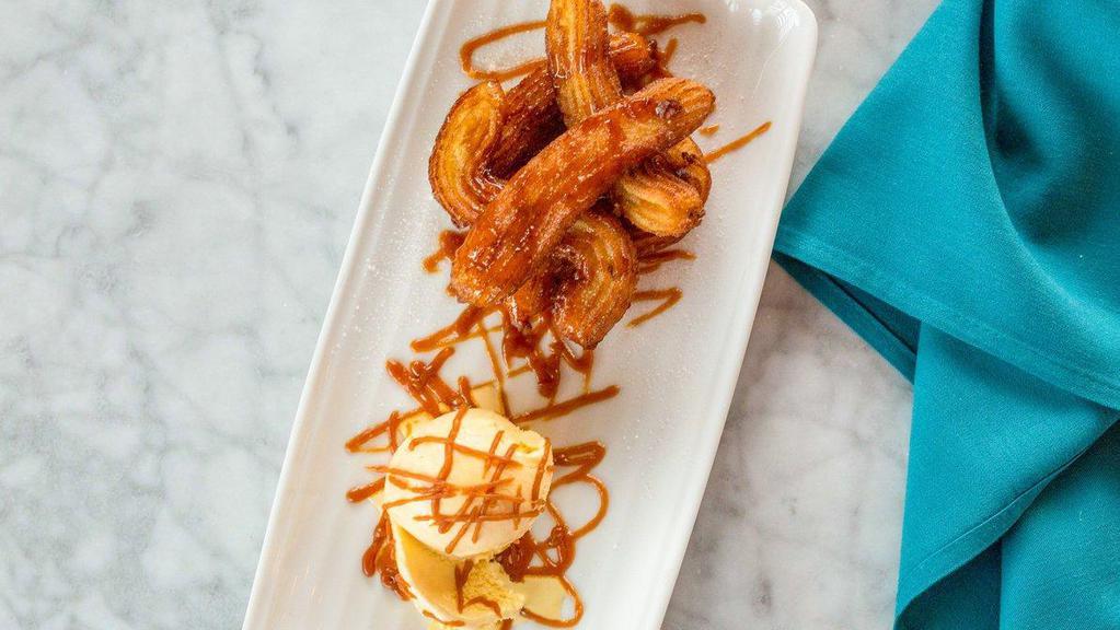 Churros · Fried dough tossed in cinnamon sugar with melted chocolate sauce and a scoop of vanilla ice cream
