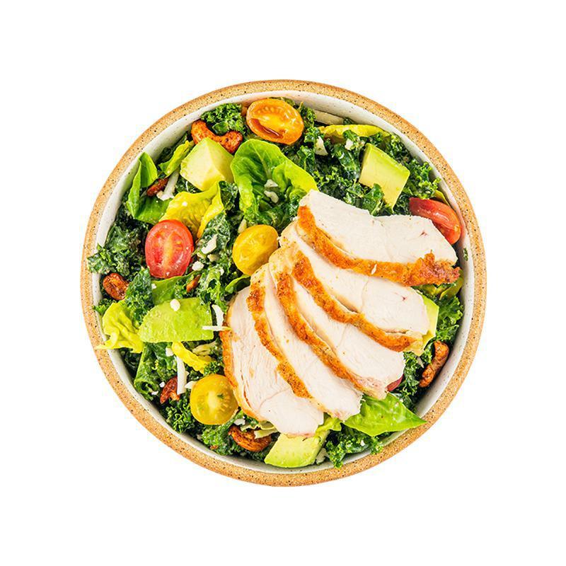 Herb Chicken Kale Caesar Salad · Cashew Kale Caesar, farm greens with mint, herb roasted chicken breast, avocado, shaved cauliflower, cherry tomatoes, spicy cashews, toasted breadcrumbs, and more cashew Caesar dressing on the side. Contains wheat/gluten, tree nuts (cashew).