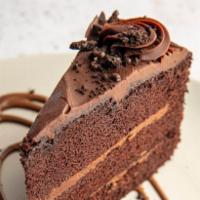Chocolate Cake · A slice of rich dark chocolate cake served with chocolate crumble topping and chocolate gana...