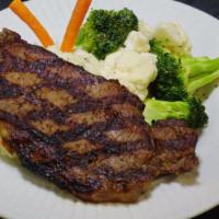 Ribeye Steak · A flavorful 9 oz ribeye steak served with mashed potatoes and grilled seasonal vegetables.